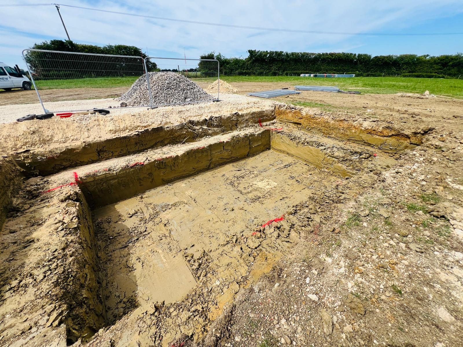 A large excavated foundation pit marked out with red line paint at a 24MW solar site in Cambridgeshire.