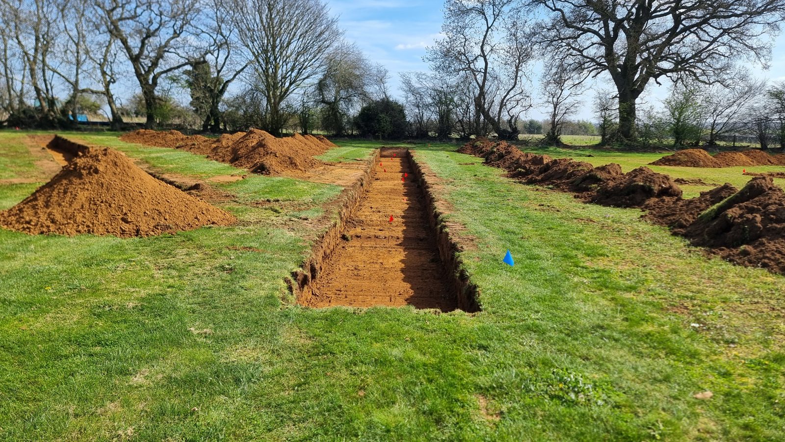 Archaeological trenches marked with flags in Northamptonshire.