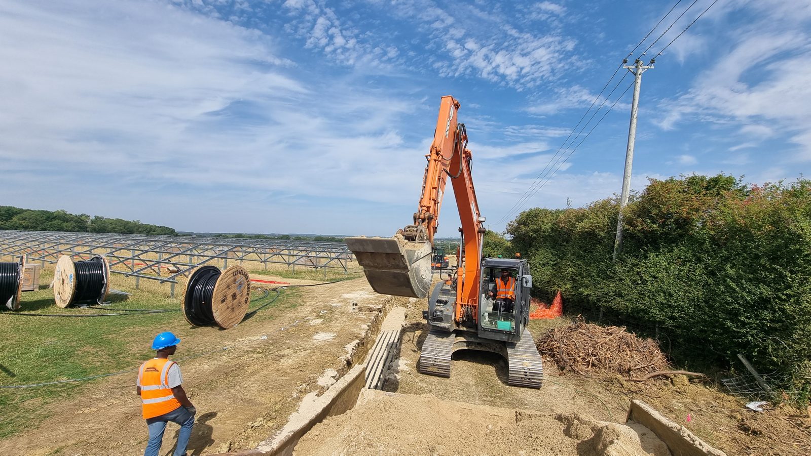 A cable trench with cable drums ready for installation at a 29MW solar site in Oxfordshire.
