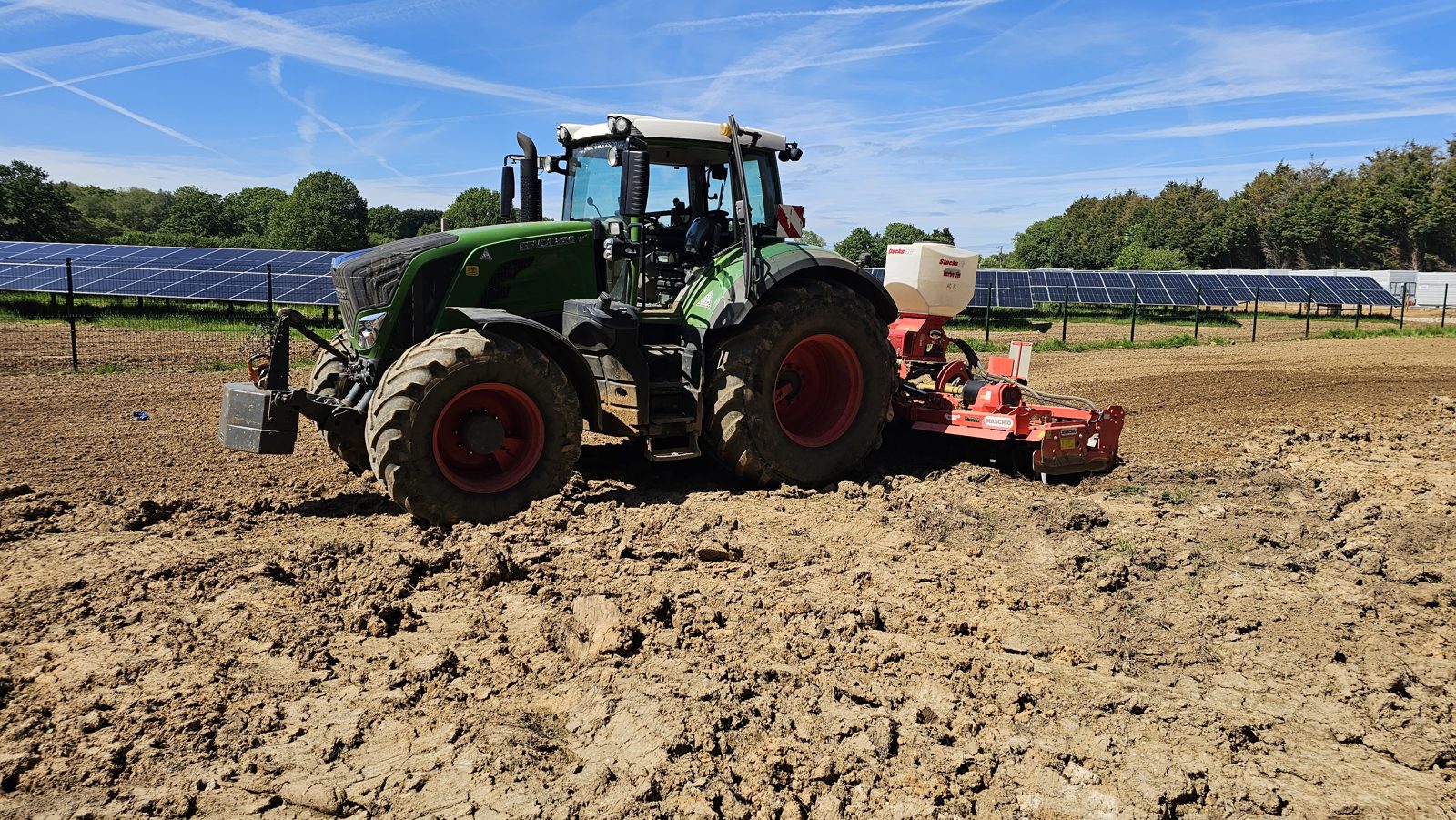 A tractor with a seeder working cultivated ground for reinstatement at a completed solar site in East Sussex.