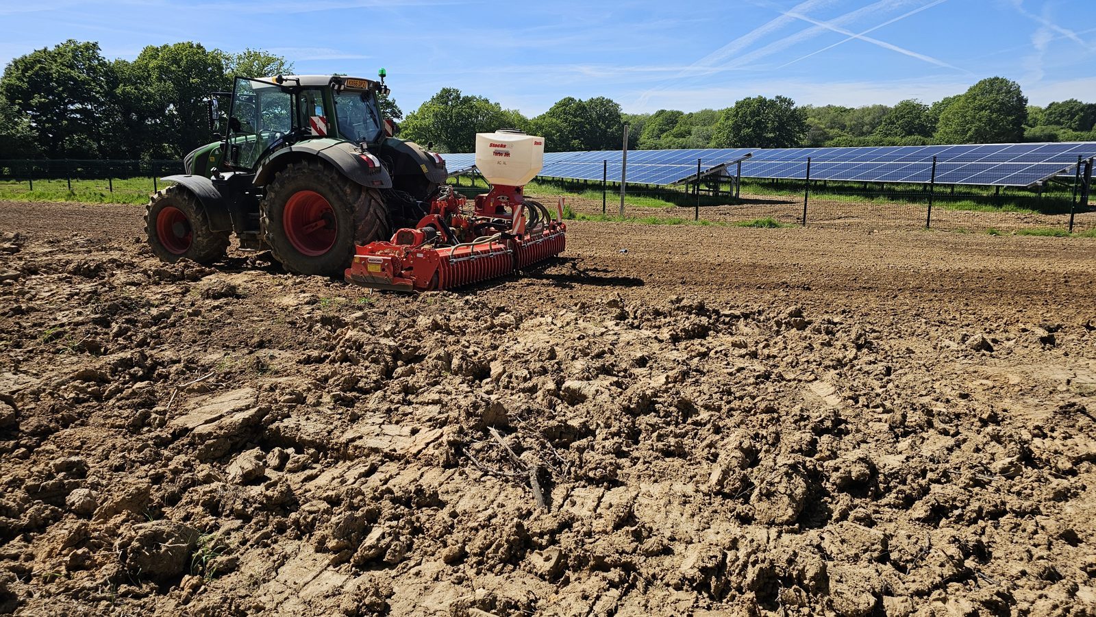 A tractor cultivating and seeding ground for reinstatement at a completed solar site.