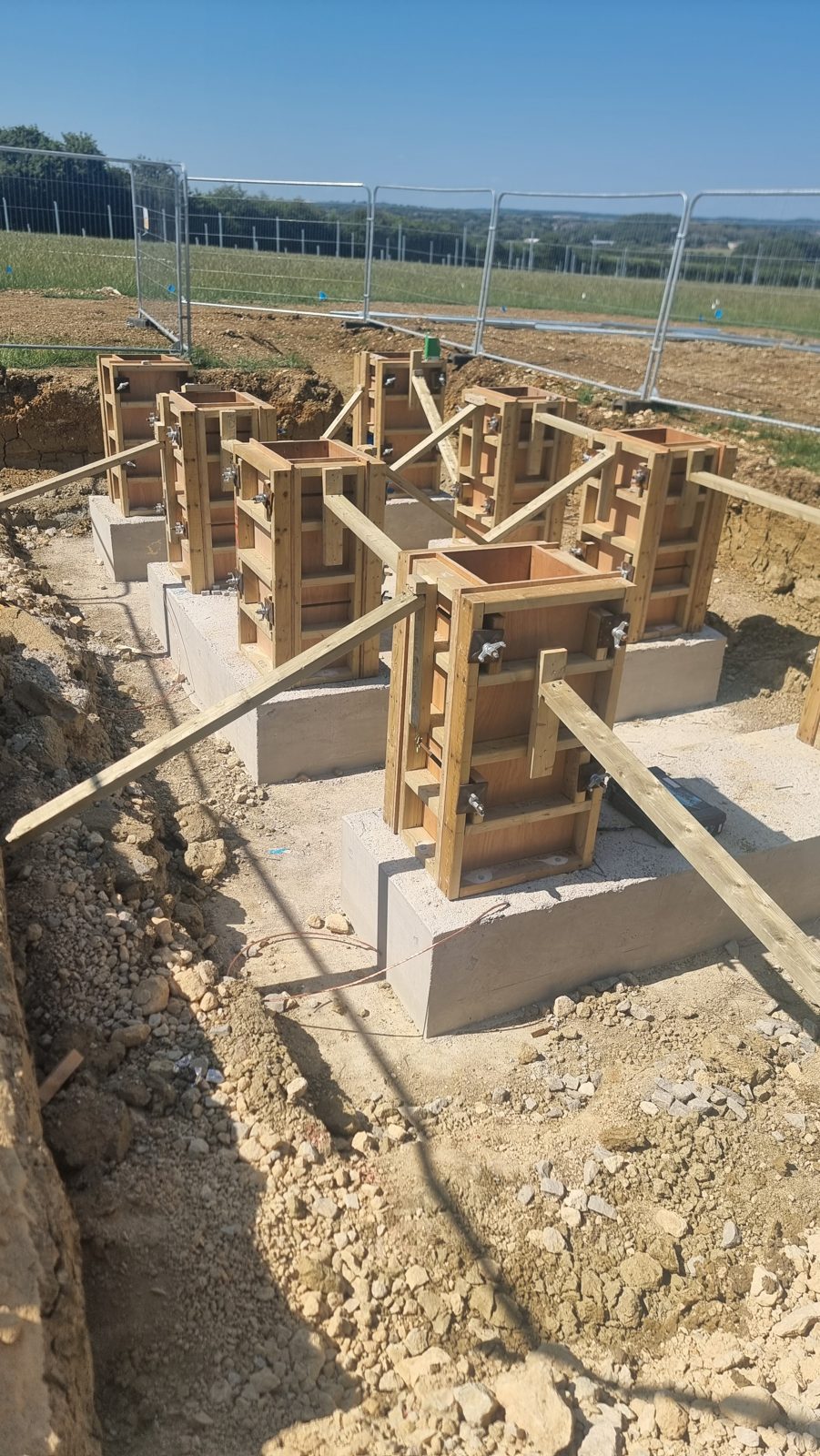 An array of timber column formwork set on cast concrete bases, ready for pouring, in Cambridgeshire.